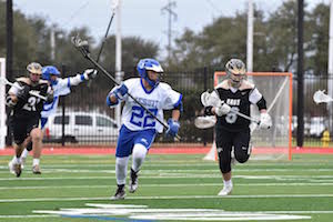 Jesuit Lacrosse player playing on field.