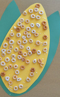 corn on the cob with Cheerios glued on it