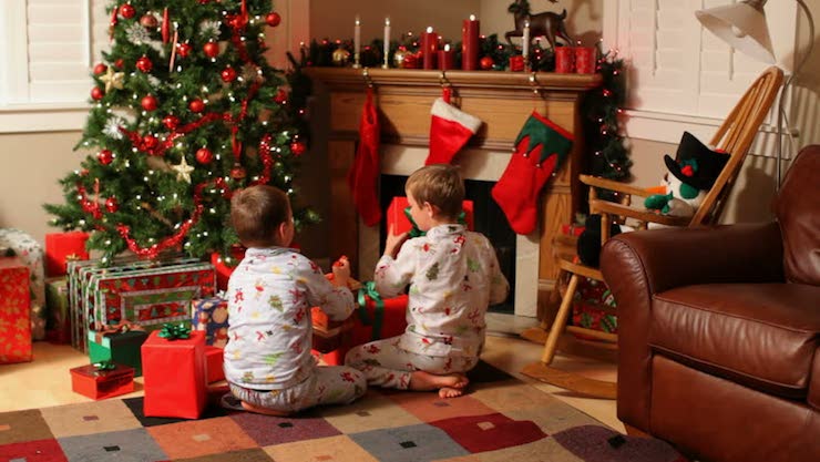 children looking at gifts under christmas tree