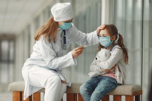 Doctor and child both demonstrating mask safety